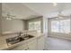 This kitchen features stainless steel double sink, white cabinets and appliances and wood look floors at 4627 E Mcneil St, Phoenix, AZ 85044