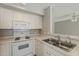 Kitchen features white cabinets and appliances, stainless steel double sink, and light countertops at 4627 E Mcneil St, Phoenix, AZ 85044