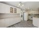 Bright kitchen features white cabinets, appliances, gray wood floors and a multi-light ceiling fan at 4627 E Mcneil St, Phoenix, AZ 85044