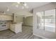 This kitchen features wood look floors, white cabinets and appliances, and a large window to the patio at 4627 E Mcneil St, Phoenix, AZ 85044