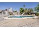Backyard view of in-ground pool with slide, surrounded by desert landscape with a light tan home in the background at 4627 E Mcneil St, Phoenix, AZ 85044