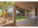 A covered back patio offers shade overlooking a private backyard with mature trees and a small fountain at 4911 E Holmes Ave, Mesa, AZ 85206