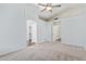 Spacious bedroom features neutral carpet, a ceiling fan, a walk-in closet, and access to the Primary bath at 4911 E Holmes Ave, Mesa, AZ 85206