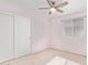 A clean bedroom with closet doors, neutral carpet, a ceiling fan and a window at 4911 E Holmes Ave, Mesa, AZ 85206