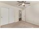 Neutral-toned bedroom boasts carpet, ceiling fan, and closet for a comfortable living space at 4911 E Holmes Ave, Mesa, AZ 85206