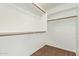 A tidy walk-in closet featuring multiple hanging rods and upper shelves for organized storage at 4911 E Holmes Ave, Mesa, AZ 85206