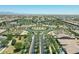 Aerial view of the neighborhood with palm tree lined street and a community pool in the distance at 5515 S Caisson Way, Mesa, AZ 85212