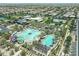 Neighborhood aerial view showcases community pool, tennis courts, lush landscape and homes in a Gathering-friendly neighborhood at 5515 S Caisson Way, Mesa, AZ 85212
