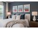 Well-lit bedroom with a plush queen bed adorned with elegant bedding, artwork, and a sunny window view at 5515 S Caisson Way, Mesa, AZ 85212