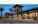 Community clubhouse with modern architecture, towering entryway, desert landscaping, and inviting exterior lighting at 5515 S Caisson Way, Mesa, AZ 85212