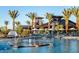 Stunning community pool area with palm trees, lounge chairs, splash pad, and modern clubhouse at 5515 S Caisson Way, Mesa, AZ 85212