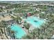 Aerial view shows the expansive community pool, a circular roundabout and surrounding homes in the neighborhood at 5515 S Caisson Way, Mesa, AZ 85212