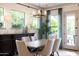 Bright dining room features a modern chandelier, buffet, and large windows with a view to the porch at 5515 S Caisson Way, Mesa, AZ 85212