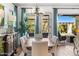 Elegant dining area features a modern chandelier, stylish curtains, and access to the patio at 5515 S Caisson Way, Mesa, AZ 85212