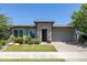Inviting home featuring stone accents, modern front door, manicured lawn, and paver driveway at 5515 S Caisson Way, Mesa, AZ 85212