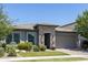 Beautiful home featuring a stone entryway, tile roof, manicured lawn, and an attached garage at 5515 S Caisson Way, Mesa, AZ 85212
