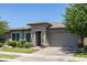 Charming home features a stone facade, tidy landscaping, and a brick paver driveway at 5515 S Caisson Way, Mesa, AZ 85212