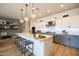 Bright kitchen features white cabinets, gray island with barstool seating, and modern pendant lighting at 5515 S Caisson Way, Mesa, AZ 85212