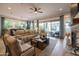 Spacious living room featuring neutral furniture, a ceiling fan, and sliding glass doors to the outside patio at 5515 S Caisson Way, Mesa, AZ 85212