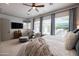 Bright main bedroom with sitting area, large windows, ceiling fan, and plush bedding, offering comfort and style at 5515 S Caisson Way, Mesa, AZ 85212