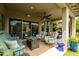 Spacious covered patio with multiple seating areas, a ceiling fan, and elegant decor at 5515 S Caisson Way, Mesa, AZ 85212