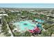 Aerial view of the community pool area with slides and splash pad surrounded by lounge seating at 5515 S Caisson Way, Mesa, AZ 85212