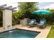 Inviting backyard pool area with stylish lounge chairs, an umbrella and built-in grill for outdoor entertaining at 5515 S Caisson Way, Mesa, AZ 85212