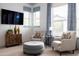 Bright sitting area with stylish chairs, a plush ottoman, and media cabinet, perfect for relaxation and entertainment at 5515 S Caisson Way, Mesa, AZ 85212