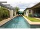 Swimming pool with a stone wall waterfall feature, built-in outdoor grill, and comfortable lounge chairs at 5515 S Caisson Way, Mesa, AZ 85212
