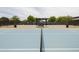 Community tennis court featuring well-maintained blue courts, black fencing, and seating at 5515 S Caisson Way, Mesa, AZ 85212