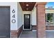 Welcoming front entry showcases a brick pillar, a stylish wooden ceiling, and a modern black front door at 640 S 34Th St, Mesa, AZ 85204