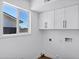 Functional laundry area features built-in cabinets, a window, and modern utility connections at 640 S 34Th St, Mesa, AZ 85204