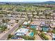 Expansive aerial view of the community showcasing lush landscaping, swimming pools, and golf course in the distance at 6620 E Paradise Ln, Scottsdale, AZ 85254