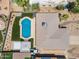 An aerial view of the backyard, featuring a pool, artificial turf, desert landscaping, and a shaded patio at 6620 E Paradise Ln, Scottsdale, AZ 85254