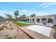 Beautiful backyard oasis with desert landscaping, a sparkling pool, modern pergola, and a grassy area for outdoor activities at 6620 E Paradise Ln, Scottsdale, AZ 85254
