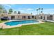 A stunning backyard showcasing a sparkling pool, lush turf, and a covered patio perfect for relaxation and entertainment at 6620 E Paradise Ln, Scottsdale, AZ 85254