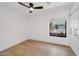 Bedroom showcasing hardwood floors, a ceiling fan, and a view of the neighborhood at 6620 E Paradise Ln, Scottsdale, AZ 85254