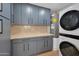 Well-organized laundry room with gray cabinets, sleek hardware, and stacked washer and dryer for efficient space use at 6620 E Paradise Ln, Scottsdale, AZ 85254