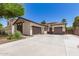 Home with a desert themed yard leading to a two car garage and an additional single car garage at 6805 S Sapphire Way, Chandler, AZ 85249