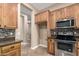 Well-equipped kitchen boasts stainless steel appliances, mosaic backsplash, and wood cabinetry with ample storage at 6805 S Sapphire Way, Chandler, AZ 85249