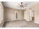 This bedroom showcases plush carpet, a ceiling fan, and a door to an ensuite bathroom at 6805 S Sapphire Way, Chandler, AZ 85249