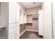 A walk-in closet with custom white storage solutions and soft carpeting at 6805 S Sapphire Way, Chandler, AZ 85249