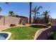 Backyard featuring a trampoline, grass, gravel, and mature landscaping at 6958 W Morning Dove Dr, Glendale, AZ 85308