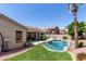 Backyard with a pool, covered patio, mature palm trees, and green grass at 6958 W Morning Dove Dr, Glendale, AZ 85308