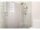 Modern bathroom showcasing a tiled shower with glass block window and patterned tile flooring at 6958 W Morning Dove Dr, Glendale, AZ 85308