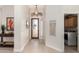 Bright foyer featuring tiled floors, decorative lighting, and access to the laundry room at 6958 W Morning Dove Dr, Glendale, AZ 85308