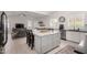 Open-concept kitchen with island, white cabinets, stainless appliances, and seamless flow to the living area at 6958 W Morning Dove Dr, Glendale, AZ 85308