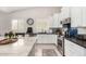 Bright kitchen features white cabinetry, stainless steel appliances, tile backsplash, and large center island at 6958 W Morning Dove Dr, Glendale, AZ 85308