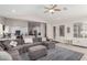 Comfortable living room features a large gray sectional, ceiling fan, and seamless flow to the kitchen at 6958 W Morning Dove Dr, Glendale, AZ 85308