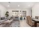 Open-concept living room featuring neutral tones, large windows, and a dining area at 6958 W Morning Dove Dr, Glendale, AZ 85308